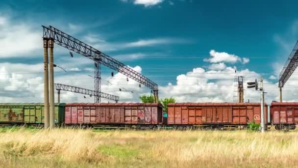 Arka plan mavi gökyüzünde bir demiryolu üzerinde kargo vagonları zinciri. Timelapse 4k — Stok video