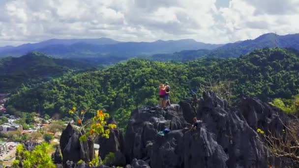 Jonge paar toeristen klassement op de top van de berg Taraw in El Nido, Palawan, Filippijnen. Bovenaanzicht 4k — Stockvideo
