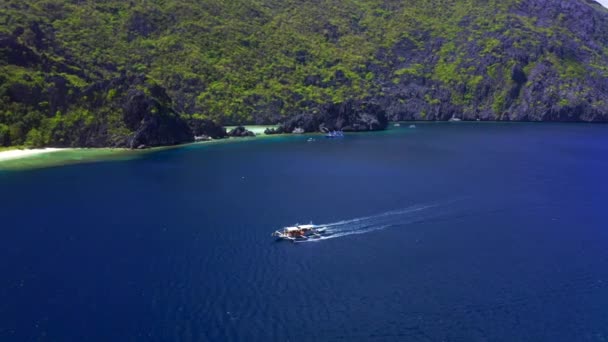 Veduta aerea drone bianco tradizionale barca filippina galleggiante sulla superficie dell'acqua blu chiaro. El Nido, Palawan, Filippine — Video Stock