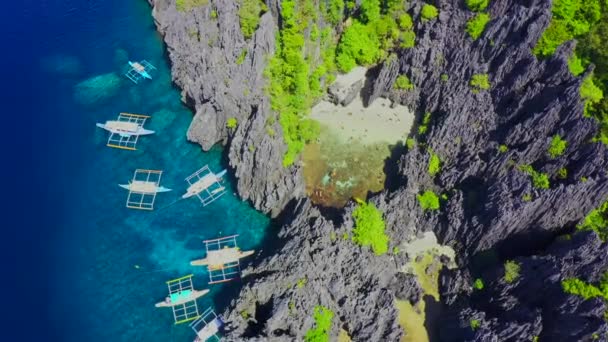Vista aérea de drones de nadadores dentro de una pequeña laguna tropical oculta rodeada de acantilados - Secret Lagoon, isla Miniloc en El Nido, Palawan, Filipinas — Vídeos de Stock