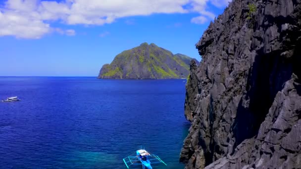Légi drone tekintettel a fehér hagyományos filippínó csónak úszó tetején tiszta kék víz felszínén. El Nido, Palawan, Fülöp-szigetek — Stock videók