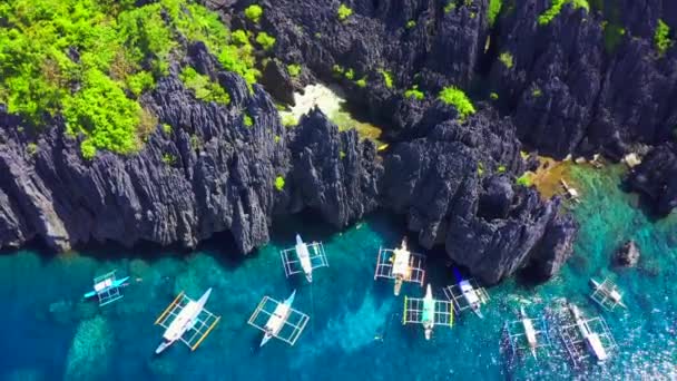 Luftaufnahme der Schwimmer in einer winzigen, versteckten tropischen Lagune, die von Klippen umgeben ist - geheime Lagune, Miniloc-Insel in El Nido, Palawan, Philippinen — Stockvideo