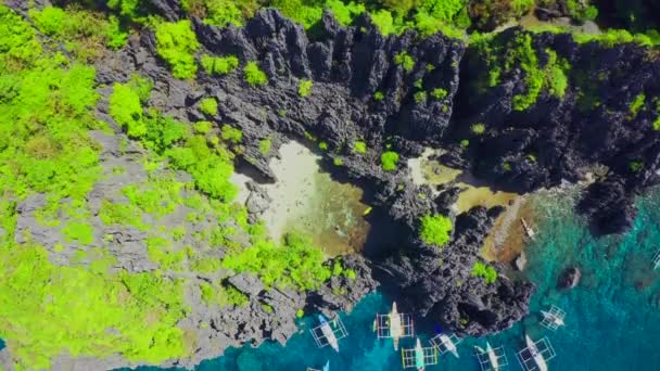 Kayalıklarla çevrili küçük bir gizli tropikal lagün içinde yüzücülerin havadan drone görünümü - Secret Lagoon, El Nido Miniloc adası, Palawan, Filipinler — Stok video