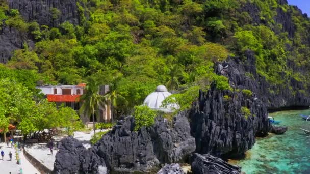 Aerial drone view of Matinloc Island in the Bacuit Archipelago complete with limestone mountains and tourist people — Stock Video