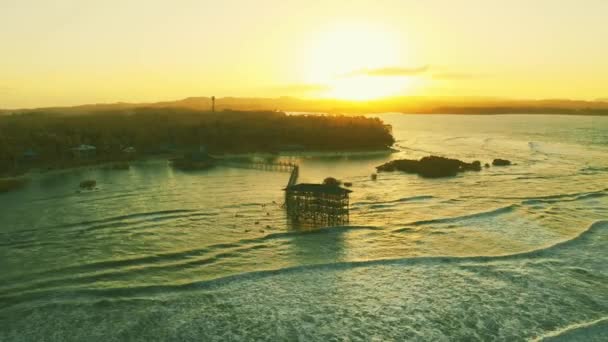 Grandi onde stanno arrivando e Bellissimo paesaggio al tramonto sul ponte di legno sulla spiaggia di Cloud 9, Isola di Siargao Filippine . — Video Stock