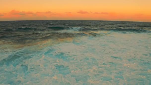 Onda oceânica colorida. Água do mar em forma de crista. Luz do pôr-do-sol e belo céu nebuloso — Vídeo de Stock