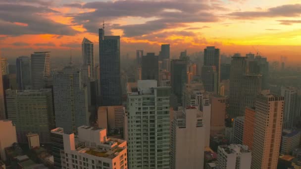 Восход солнца в центре города с высоты с несколькими небоскребами в городе Манила, Филиппины. Воздушный 4K — стоковое видео