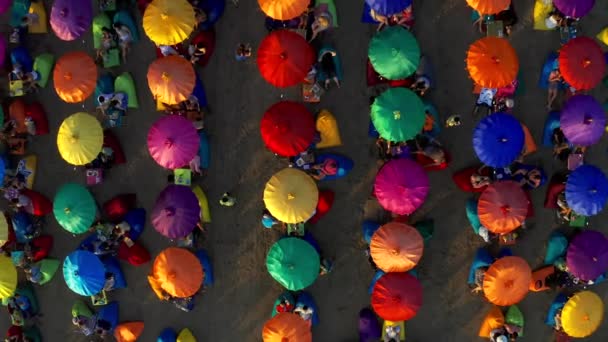 Renkli plaj şemsiyeleri ve yaz tatilini Seminyak plajında geçiren insanlar. 15 Ocak 2020: Bali, Endonezya. — Stok video