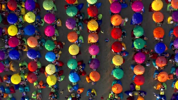 Turista desfrutando de guarda-chuvas coloridos em Seminyak Beach, um destino turístico popular na famosa Ilha Bali. 15 de janeiro de 2020: Bali, Indonésia . — Vídeo de Stock