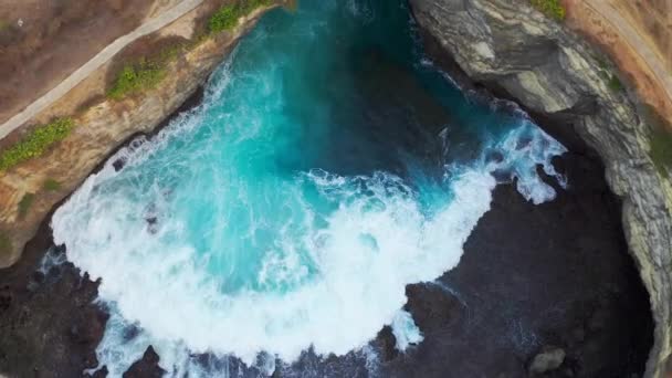 Skaliste wybrzeże. Kamienny łuk nad morzem. Zniszczona plaża, Nusa Penida, Bali, Indonezja. Widok z powietrza 4K — Wideo stockowe