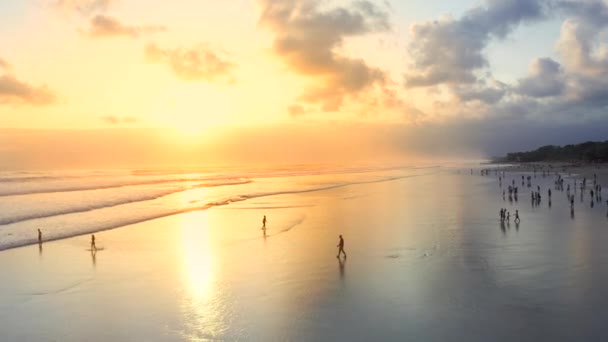 Lidé na Seminyak Beach při západu slunce nad oceánem. Letecký pohled 4K — Stock video