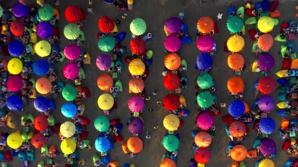 Toeristische genietend van kleurrijke paraplu 's in Seminyak Beach, een populaire toeristische bestemming op het beroemde Bali eiland. 15 januari 2020: Bali, Indonesië. — Stockvideo