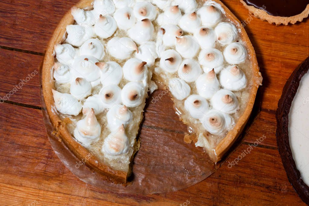 Apple cake with meringue on wooden background