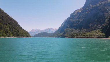 Beyaz bir plajın insansız hava aracı görüntüsü ve berrak mavi su.