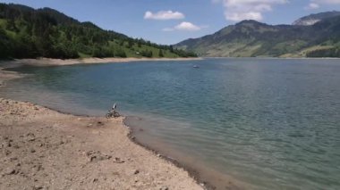 Dağ motorcusu gölde kayalık sahilde gezintiye çıkıyor..