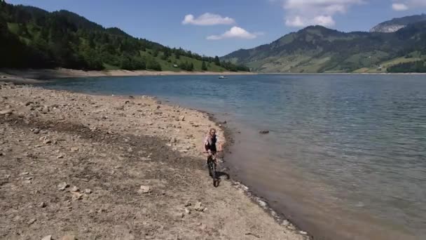 Mountain Biker Nead Lago Indo Para Passeio Praia Rochosa — Vídeo de Stock