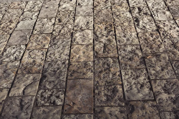 Ancient stone pavement texture. Granite cobblestoned pavement background.
