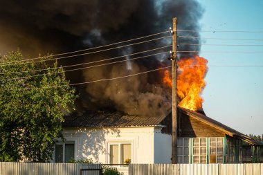 Yanan bir evden çıkan alevler, güçlü ve korkunç bir yangın.