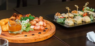 Tavuklu mezeler, nugget ve ahşap tabakta soslu rulo köfte.