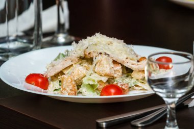 Bir restoranda, masada beyaz tabakta Sezar salatası.