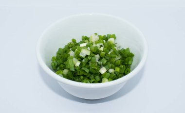 beyaz zemin üzerine kıyılmış yeşil soğan