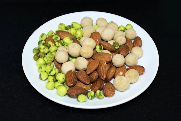 Mixed Almonds, peanuts and green peas on background