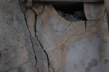 çatlaklar ve gevşek alçı pi ile eski çöken duvarın bir parçası