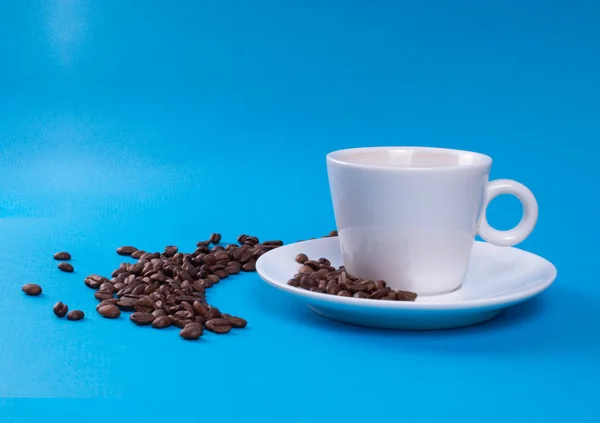 Coupe et soucoupe à côté de laquelle les grains de café sont versés — Photo