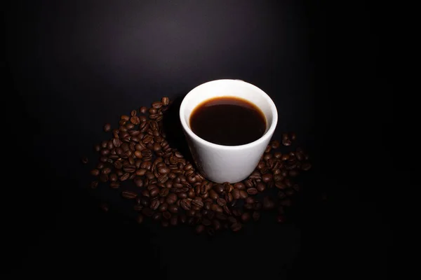 Copa de café y granos de café con iluminación de fondo — Foto de Stock