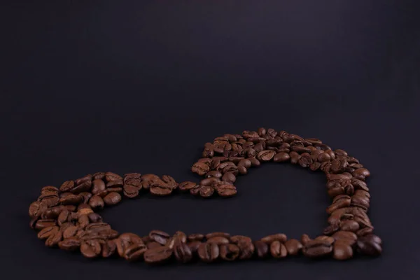 Крупный план контура сердца кофейных зерен на темных S — стоковое фото