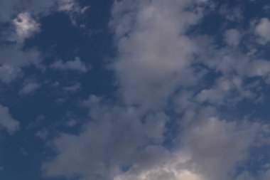 güneş ışınları nın geçtiği mavi bir gökyüzüne karşı gri bulutlar 