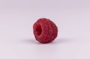 Beyaz arka plan üzerinde döşeme bir izole kırmızı ahududu yan görünümü