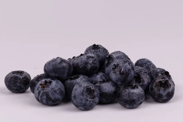 Sida framsidan av en hög med våta blåbär på en vit bakgrun — Stockfoto