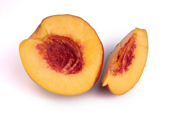 A half and a slice of a peach laying on white background — Stock Photo, Image