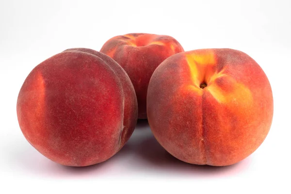 Three red orange freshly collected peaches laying next to each o — Stock Photo, Image