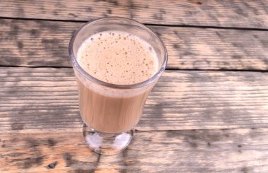 Bir bardak sıcak kahvenin üstünde duran cam bardağın en yakın görüntüsü.