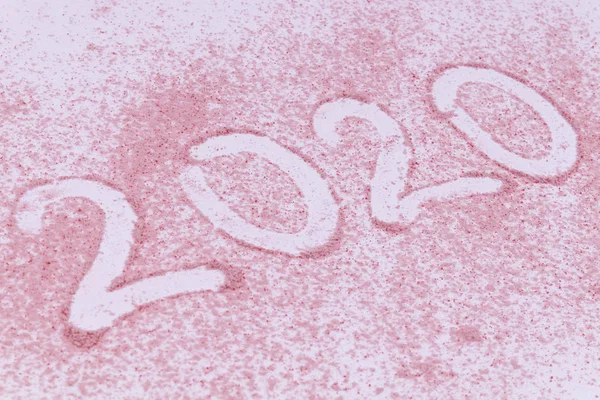 Année 2020 date faite de trace d'un doigt sur sable rose — Photo