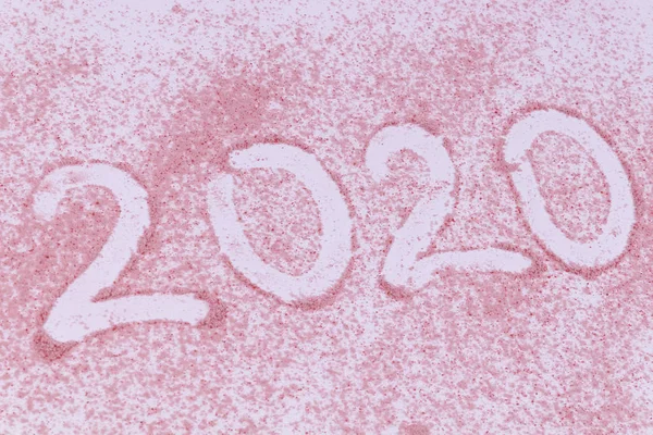 Nouvel an 2020 date écrite sur sable rose posée sur fond blanc — Photo