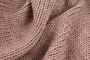 Kalın, açık bej yün bir battaniyede bir sürü pileli