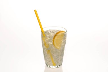 Bir serinletici bardak limonata bir dilim limon ve su boncuk ile terleme bir sarı saman.