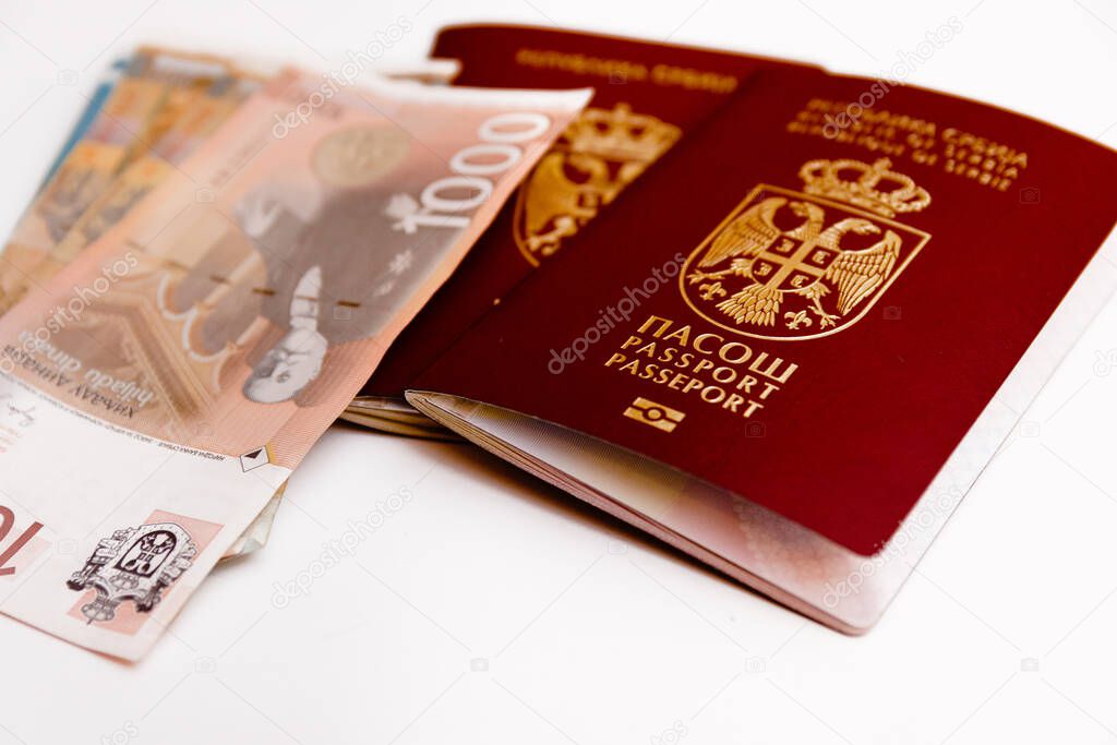 Serbian biometric passport with Serbian paper money around, isolated on white background