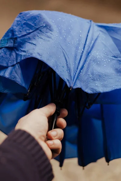 潮湿的雨伞在男人的手中 雨滴四溅 手指按下按钮打开伞 — 图库照片
