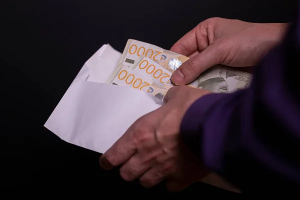 Adamın elleri Sırp parasıyla dolu kağıt kapağı tutuyor, 2000 dinar.