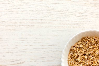 Tahta arka planda kuru yulaf. Kase sağ alt köşede.. 