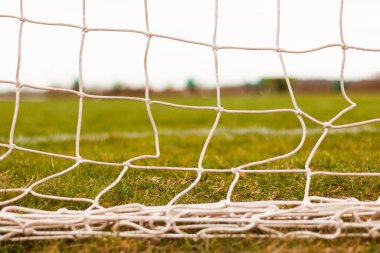 Fonu bulanık yeşil çimlerle odaklanmış futbol golü. 