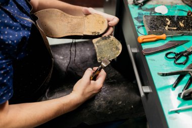 Erkek ayakkabıcı ayakkabı tabanını çıkarmak için pense kullanıyor. Ayakkabı tamircisi.. 