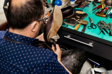 Erkek ayakkabıcı ayakkabı tabanını çıkarmak için pense kullanıyor. Ayakkabı tamircisi.. 