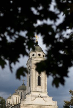 Kilisenin tepesine bakan ağaç yaprakları, bulutlar...