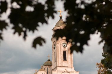 Kilisenin tepesine bakan ağaç yaprakları, bulutlar...