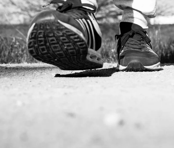 Man in sneakers walking forward. Close up of sports shoes moving toward camera, front view